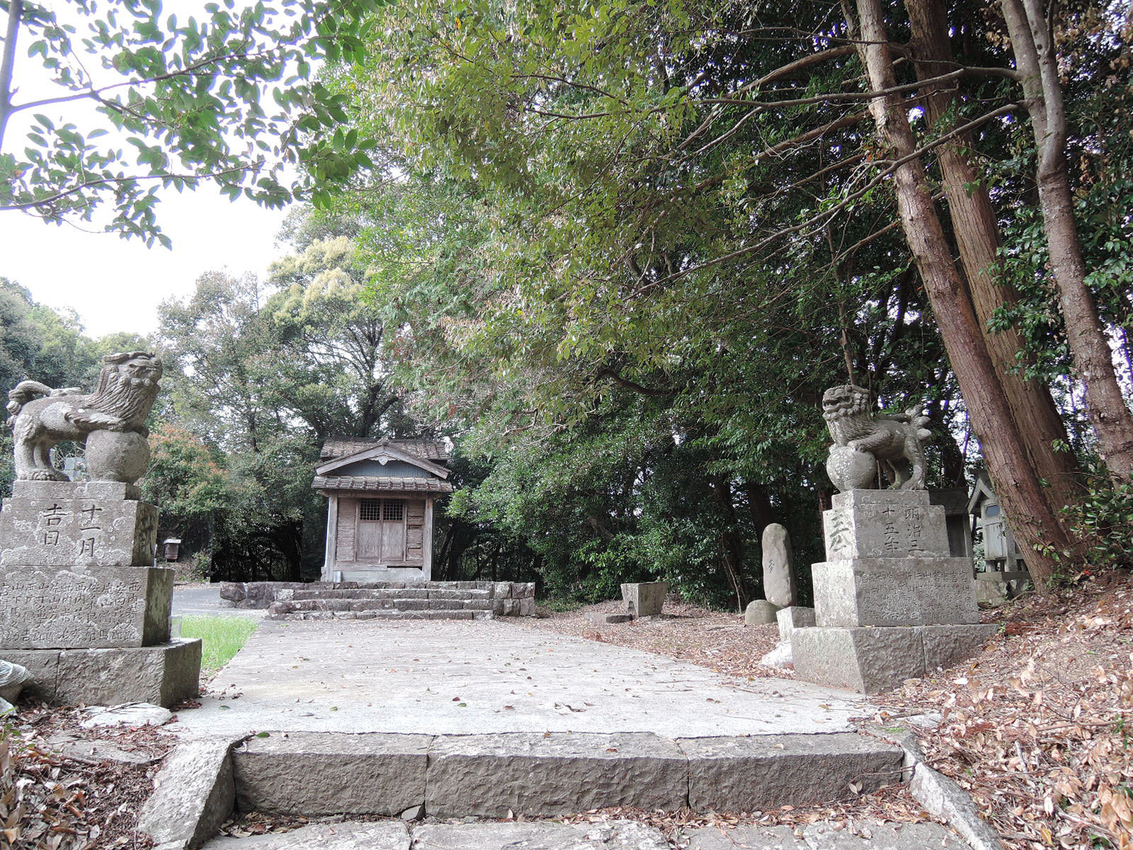 廃殿となった竹島神社の境内。階段を上り詰めた所から本殿を撮影しており、手前には階段の最後の１段があり、その左右には狛犬が写っている。右の犬の後ろに夢の碑が見える。